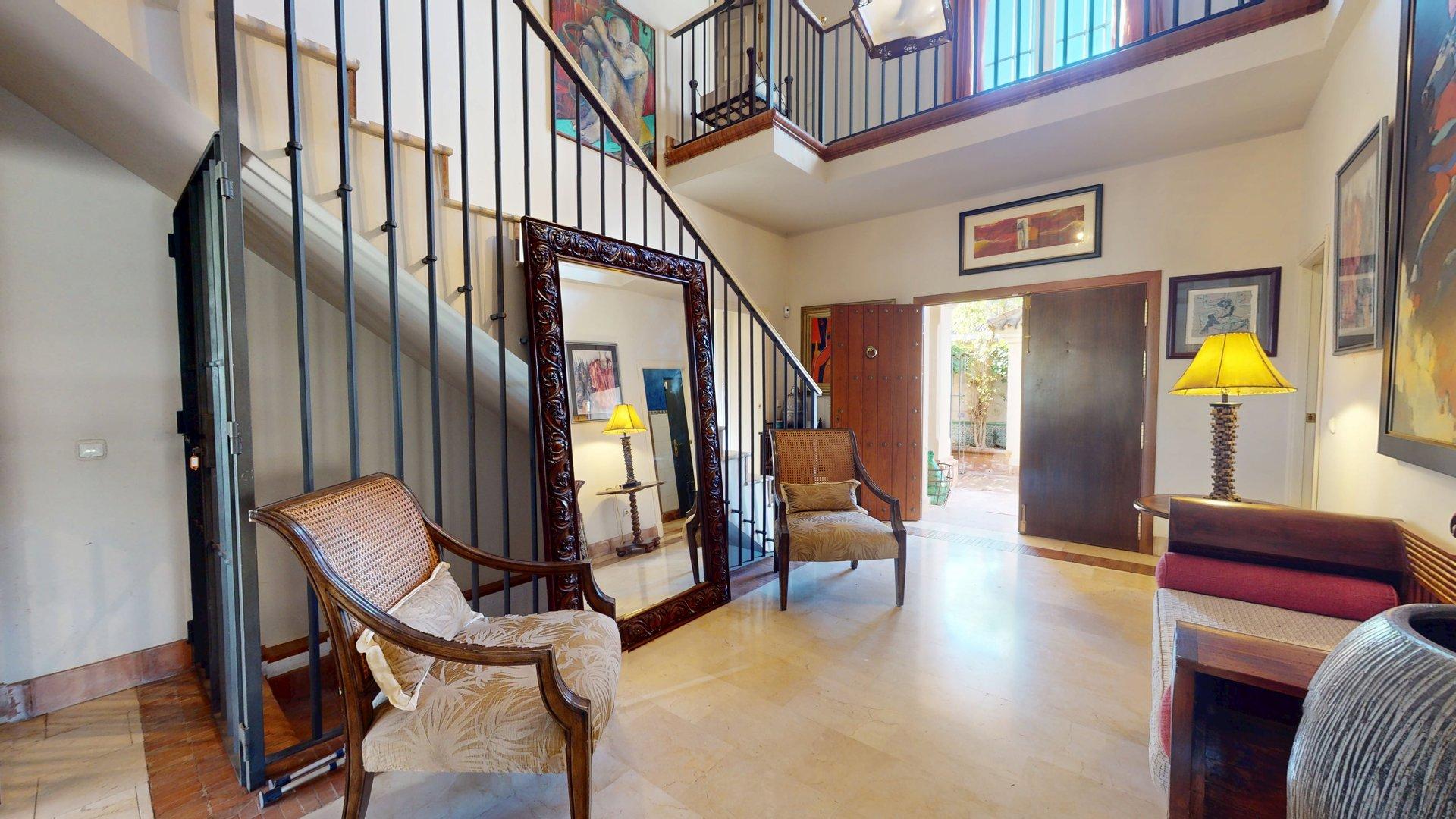 Vestíbulo de entrada con zona de estar y escalera principal