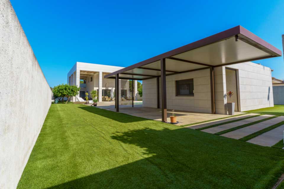 Jardín privado con porche cubierto y zona exterior ajardinada