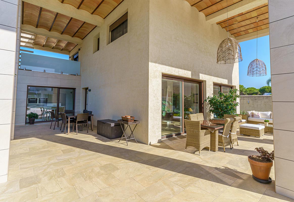 Porche cubierto con zona de comedor exterior en vivienda en venta