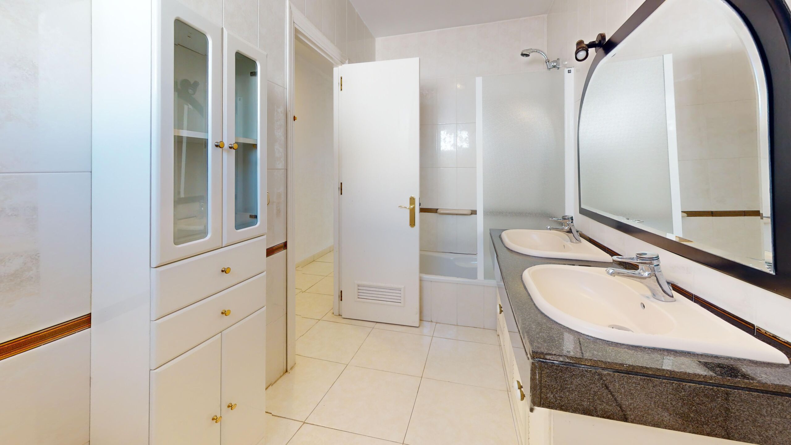 Baño amplio de casa en venta en Rota con doble lavabo y zona de almacenaje