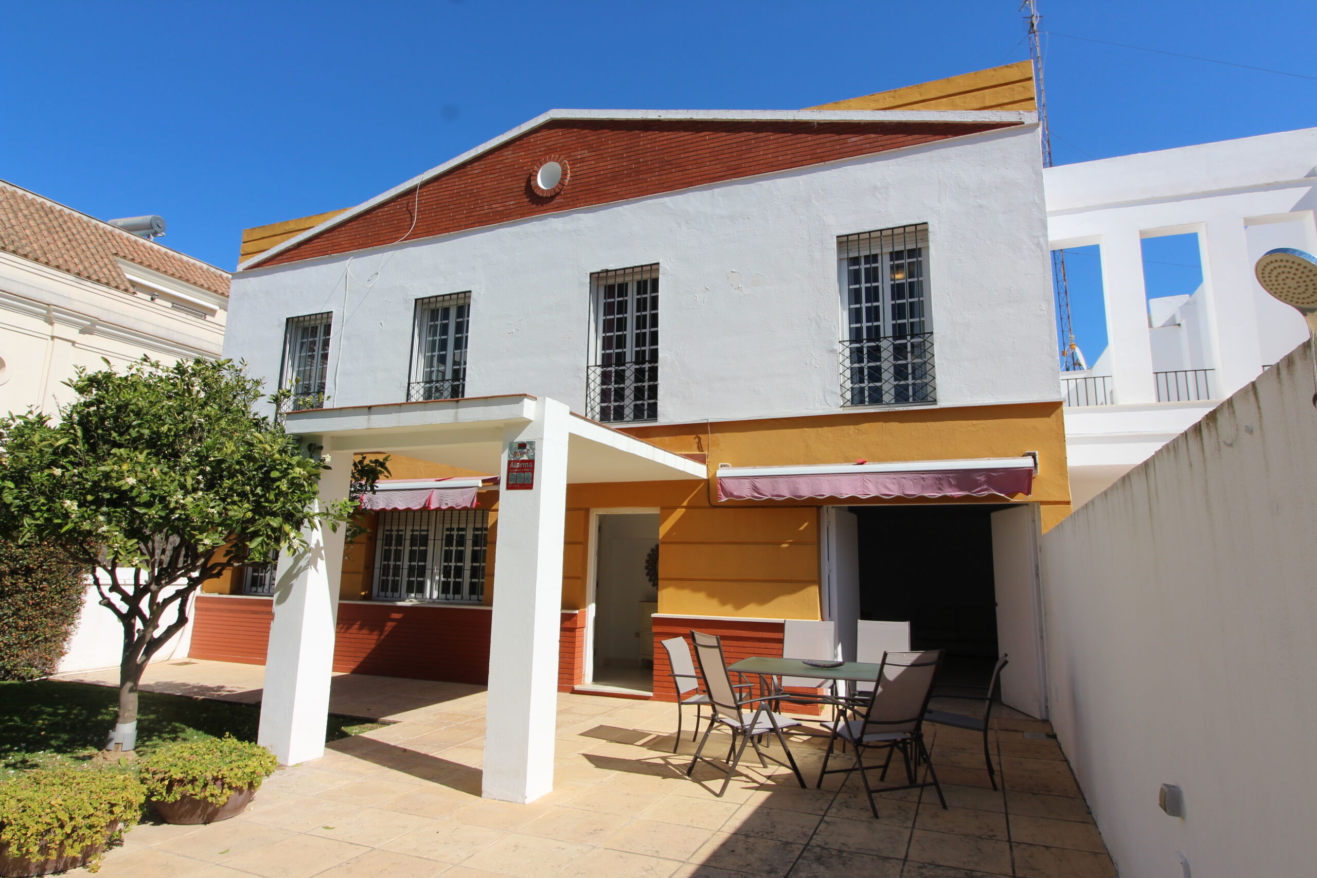 Fachada trasera de casa en venta en Rota con porche y patio exterior