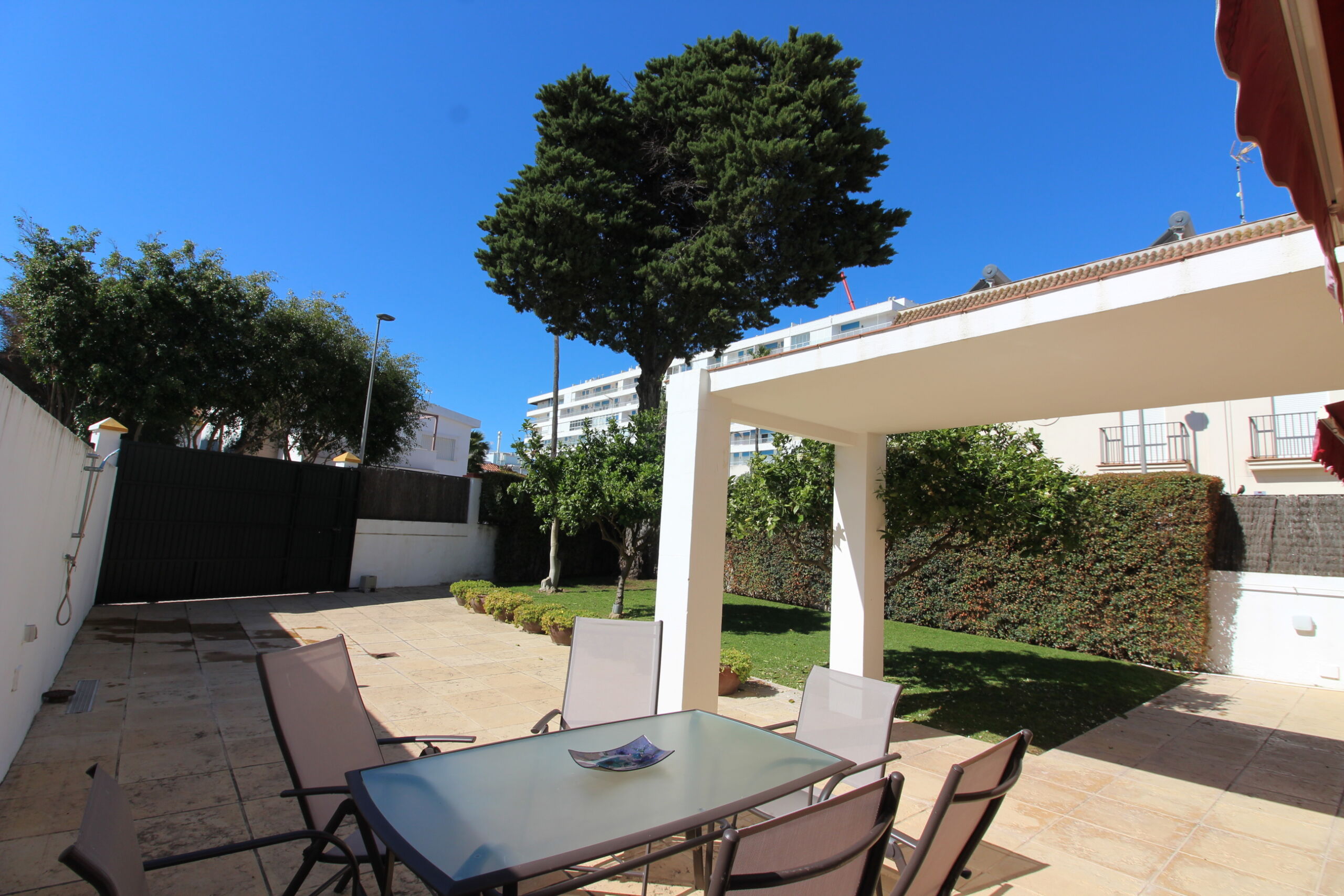 Terraza exterior cubierta de casa en venta en Rota con zona de comedor